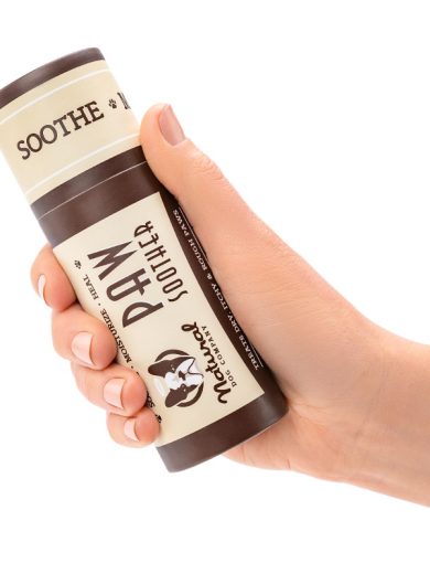 balsamo_para_almohadillas El bálsamo curativo para las patas de tu perro siendo sostenido por una mano para dimensionar el tamaño.