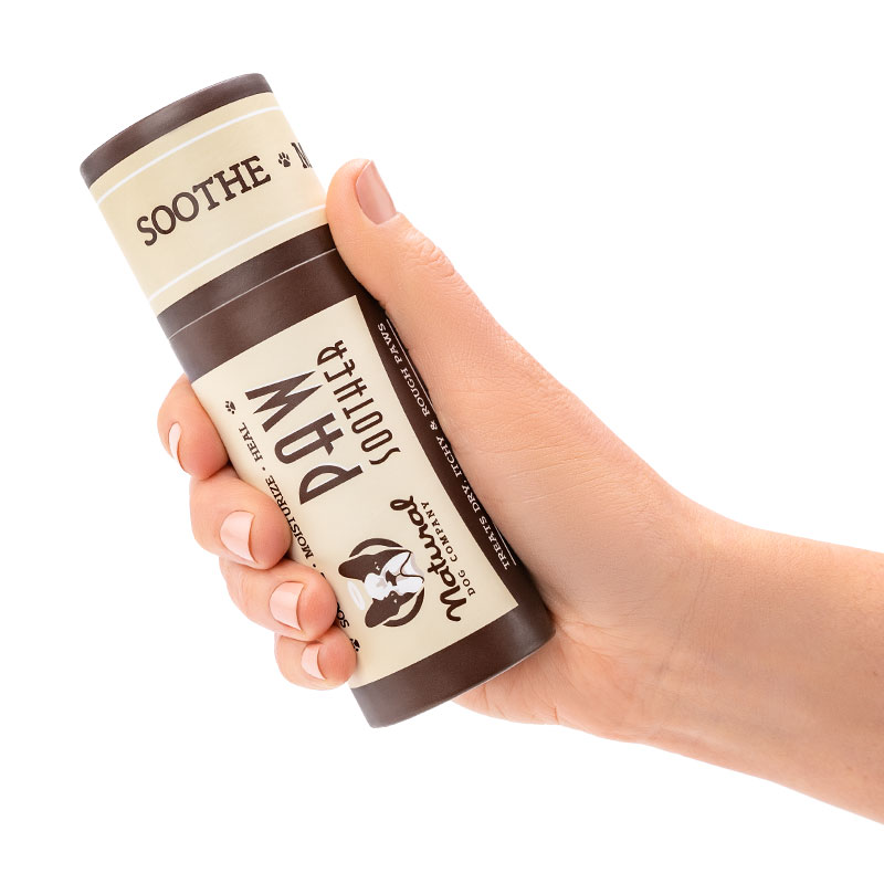 balsamo_para_almohadillas El bálsamo curativo para las patas de tu perro siendo sostenido por una mano para dimensionar el tamaño.